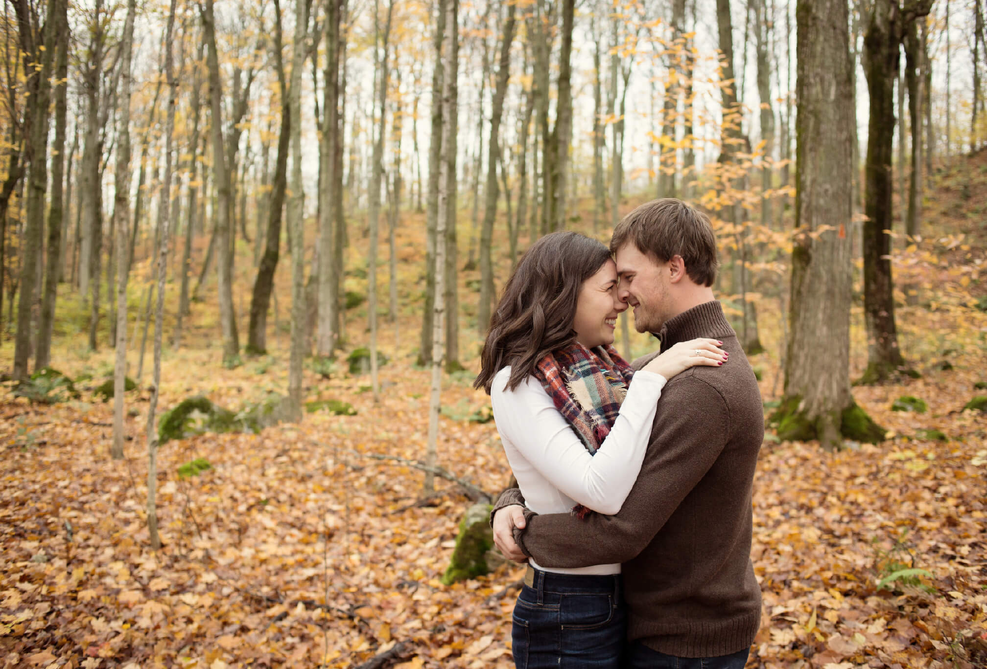 couple cuddling in fall forest