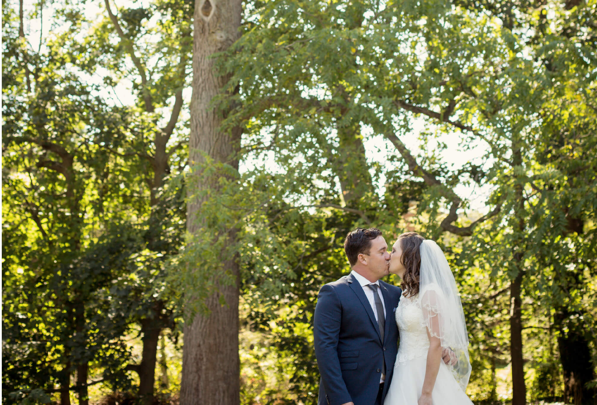 bride and groom kiss in forest