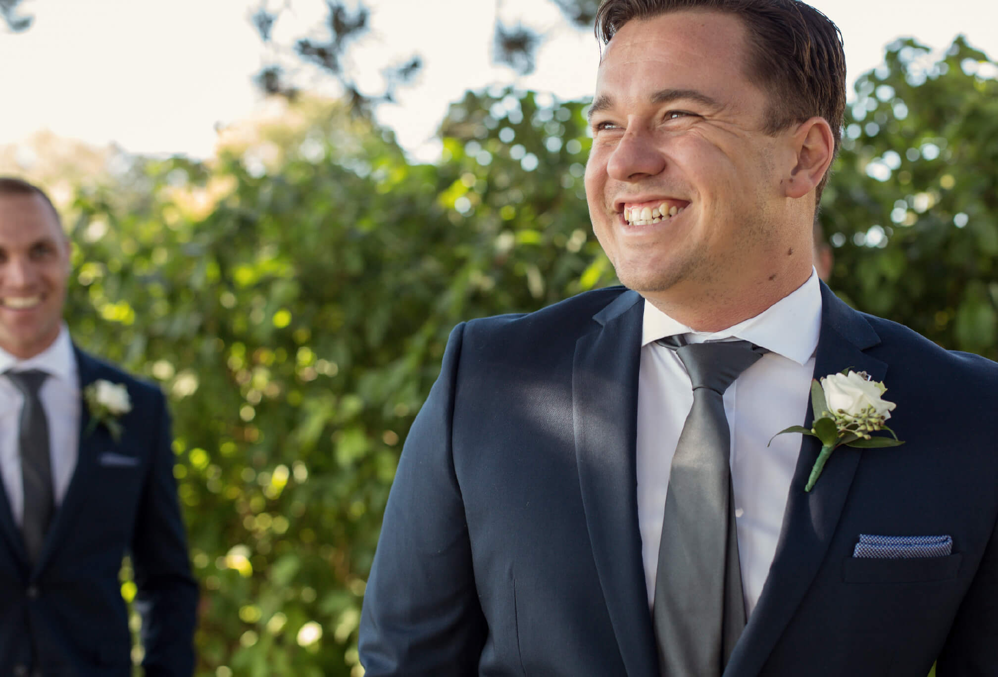 groom in blue suit smiling