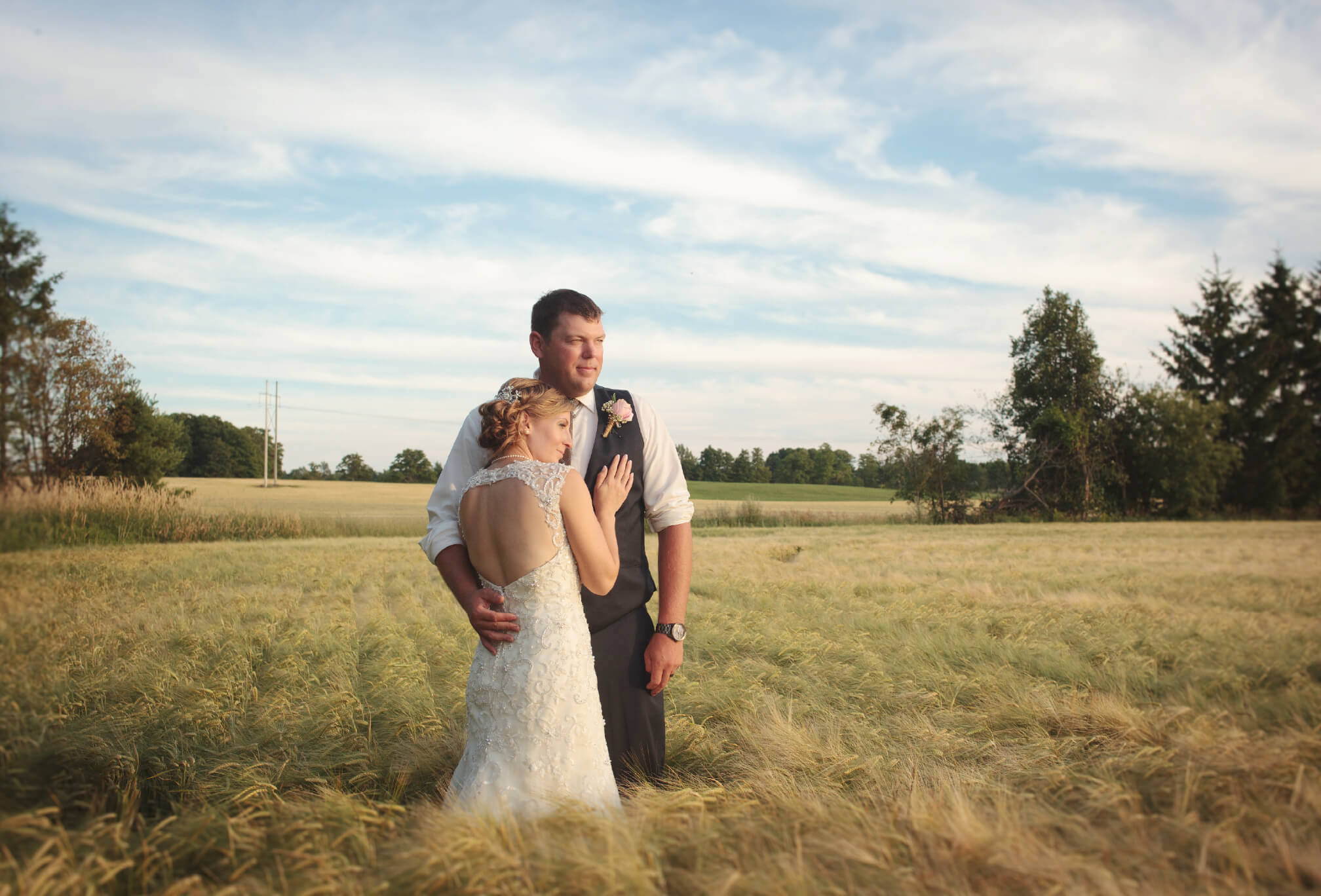 bride and groom sunset walking in field